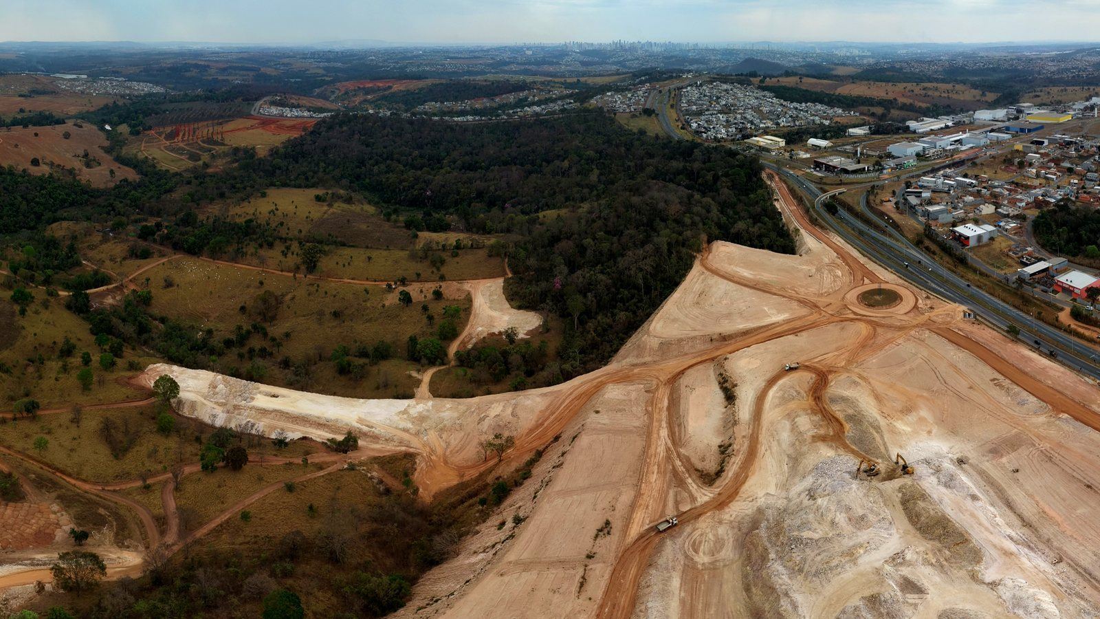 Vista aérea do Setor Comercial Salutis: terraplenagem em andamento à esquerda, a rodovia cortando a imagem e a área urbana de Senador Canedo ao fundo.